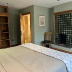 Double bedroom with green tile fire surround and pale green colour scheme