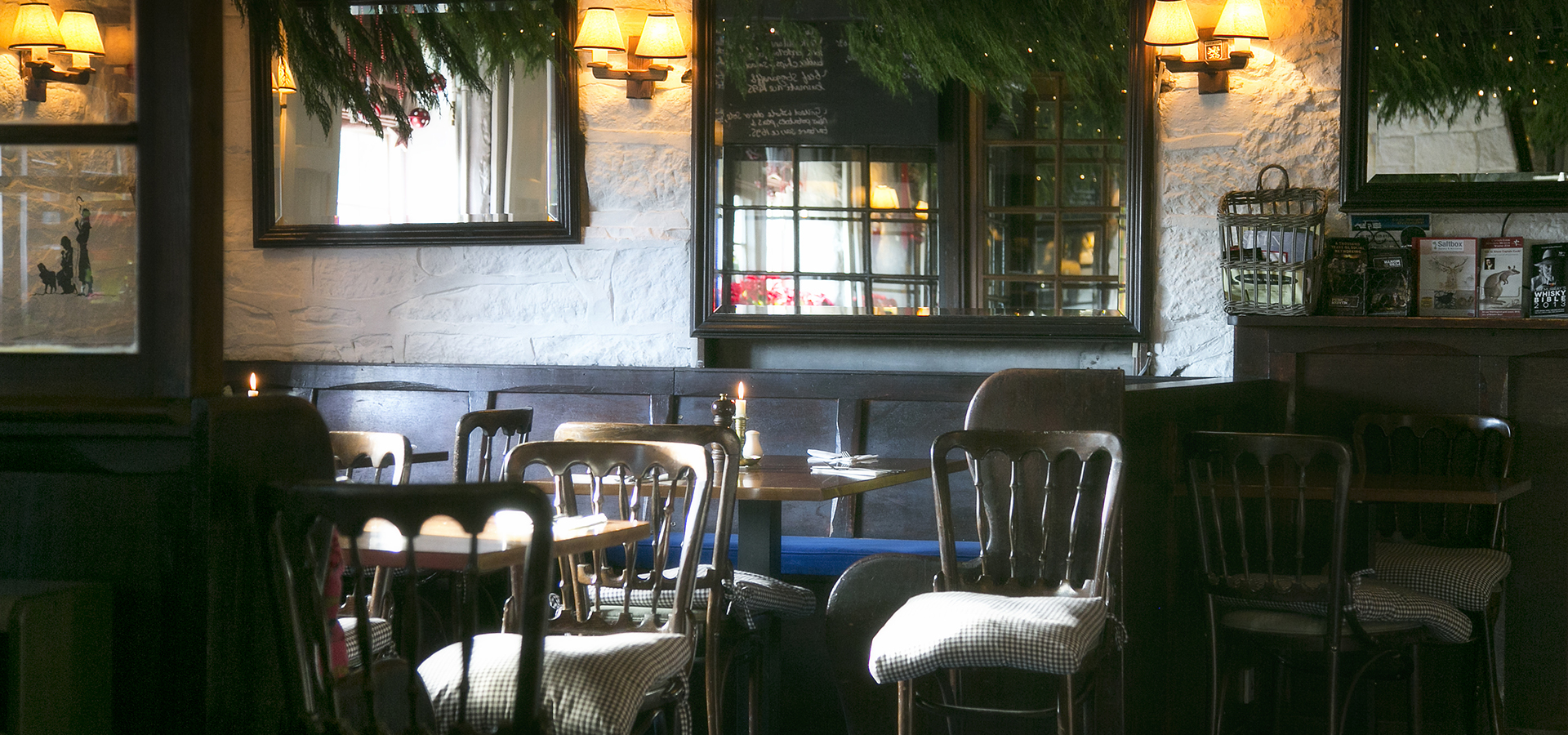Tables set for dinner service next to a mirror with twinkling lights around it