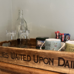 Tray with glasses and water bottle, mugs, tea and coffee